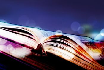 Colorful stack of textbooks with open book on its top